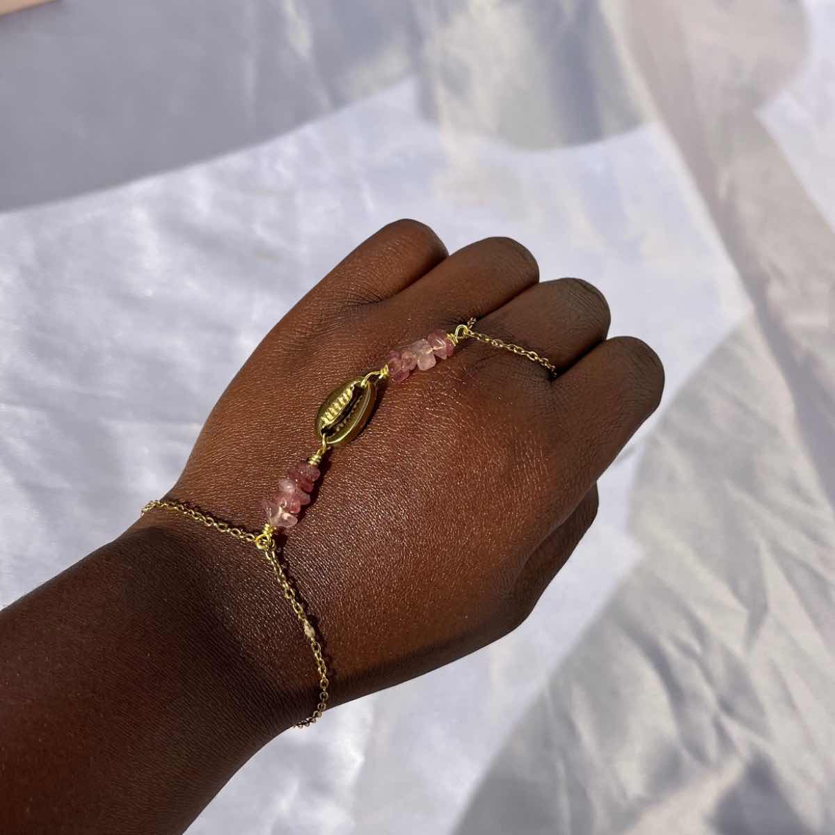 Chaîne de main dorée bohème chic avec pierre quartz fraise élégante