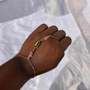 Chaîne de main dorée bohème chic avec pierre quartz fraise élégante